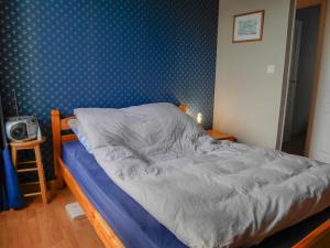 Ce lit se trouve dans une chambre dotée d'un mur bleu. dans l'établissement Appartement Le Palais, 3 pièces, 4 personnes - FR-1-418-62, au Palais