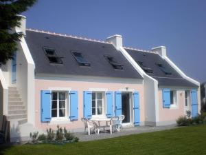 a house with blue shutters and a table and chairs at Maison de qualité avec jardin paysager à Sauzon - FR-1-418-38 in Sauzon