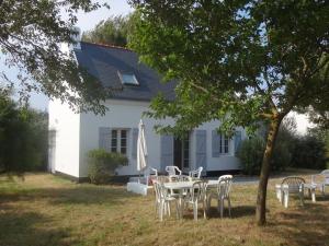a table and chairs in front of a white house at Maison lumineuse avec jardin à Sauzon, proche plage - FR-1-418-70 in Sauzon