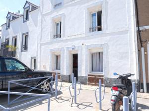 勒帕萊的住宿－Appartement Le Palais, 2 pièces, 3 personnes - FR-1-418-95，停在白色建筑前的摩托车