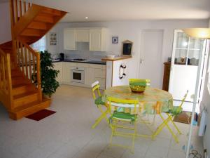 una cocina con mesa y sillas y una escalera en Maison Le Palais, 4 pièces, 7 personnes - FR-1-418-53 en Le Palais