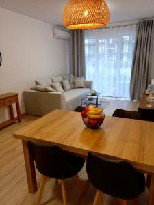 Una sala de estar con una mesa con un bol de fruta encima. en Apartament Marin, en Dziwnów