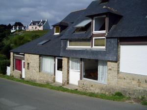 ein Steinhaus mit weißen Türen und einem schwarzen Dach in der Unterkunft Studio Le Palais, 1 pièce, 4 personnes - FR-1-418-73 in Le Palais