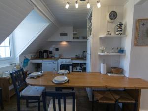 a dining room and kitchen with a wooden table and chairs at Appartement Le Palais, 4 pièces, 6 personnes - FR-1-418-58 in Le Palais