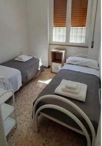 a bedroom with two beds and two windows at Villa Marisole in Torre Canne