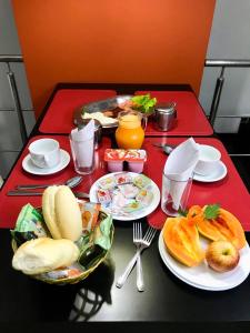 czerwony stół z talerzami żywności w obiekcie Motel Villa di Roma (Adults Only) w mieście Guarujá