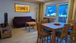 a living room with a dining room table and a couch at Gästehaus Wolf in Elbigenalp