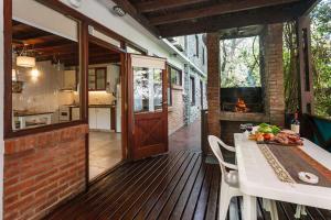 una terraza de madera con mesa y chimenea en Cabañas La Mandrágora en Mar de las Pampas