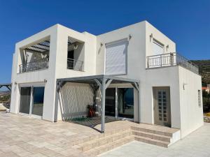 a white house with a balcony on a patio at Villa Franck I in Sitia