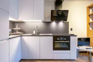 a kitchen with white cabinets and a sink at Luxe Studio Liemers in Lelystad