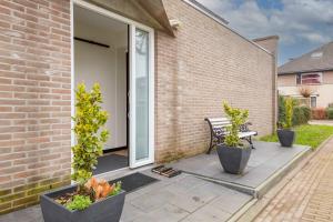 een patio met 2 potplanten en een bank bij Luxe Studio Liemers in Lelystad