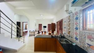 a kitchen with a sink and a staircase at Mountain Abode in Kodaikānāl