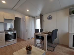 eine Küche mit einem Schreibtisch und einem Tisch in einem Zimmer in der Unterkunft Stacaravan De Maravan in Middelkerke