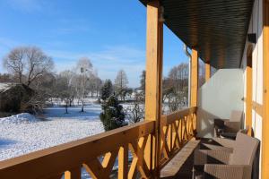 eine Veranda mit Stühlen und Schnee auf dem Boden in der Unterkunft FeWo-Zimmer-Auszeit in Drahnsdorf