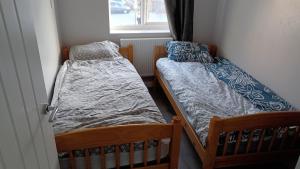 two twin beds in a room with a window at Bethel- beautiful new 1 bed house near Erith station in Erith