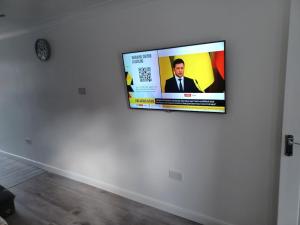 uma televisão de ecrã plano pendurada numa parede branca em Bethel- beautiful new 1 bed house near Erith station em Erith