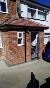 a brick garage with a door in a driveway at Bethel- beautiful new 1 bed house near Erith station in Erith