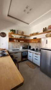 a large kitchen with a table and a refrigerator at BG Sol e Mar - Chalé Mar in Barra Grande