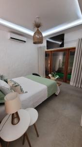 a bedroom with a bed and a table and a chair at BG Sol e Mar - Chalé Mar in Barra Grande
