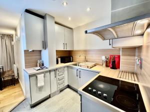 a kitchen with white cabinets and a stove top oven at City Centre Luxury Leicester Apartment in Leicester