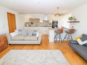 a living room with a couch and a kitchen at 4 Y Bae in Holyhead