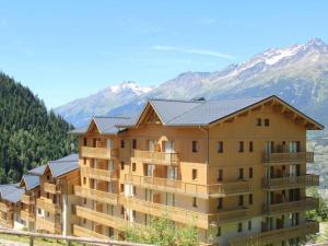 un grande condominio con montagne sullo sfondo di Appartement Valfréjus, 3 pièces, 7 personnes - FR-1-468-12 a Valfréjus