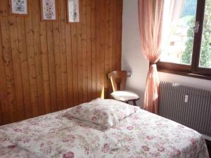 ein Schlafzimmer mit einem Bett, einem Stuhl und einem Fenster in der Unterkunft Appartement Morzine, 2 pièces, 4 personnes - FR-1-524-79 in Morzine
