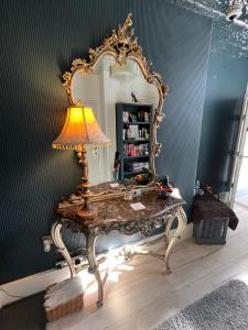 a dressing table with a mirror and a lamp on it at Gamelin in Llangollen