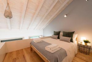 een slaapkamer met een groot bed en een houten plafond bij DOISPONTOZERO Oliveirinhas in Porto