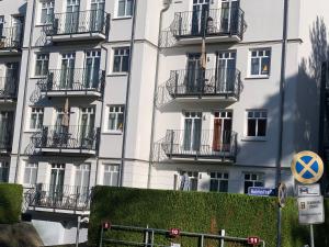 a tall white building with balconies and a sign at Appartment Ostseetraum in Ahlbeck