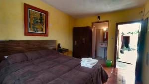 a bedroom with a large bed and a bathroom at Hostel Ibirapita in La Paloma