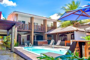 a villa with a swimming pool and a resort at Pousada da Divisa in Tamandaré