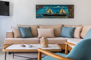 a living room with a couch with a painting of a ship at Helios Lovely Apartment in Skopelos Town