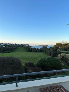einen Balkon mit Blick auf einen Golfplatz in der Unterkunft Appartement vue sur mer, 100 m de la plage in Carantec
