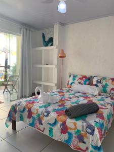 una camera da letto con un letto con un piumone colorato di Pousada Villa Encantada LGBTQIAPlus a Salvador