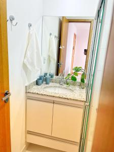 een badkamer met een wastafel en een spiegel bij Apto Itapuã próx à praia, Piscina e Sauna in Vila Velha