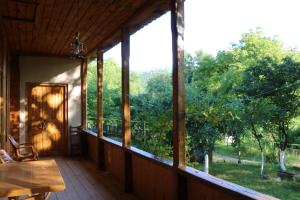 a screened porch with a view of the trees at Kipiani's guesthouse in Ambrolauri
