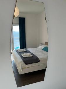 um reflexo de espelho de uma cama num quarto em Blue Art Apartment em Sveti Juraj