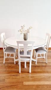 una mesa y sillas blancas con una mesa blanca y flores en Ocean Pearl Apartment W, en Funchal