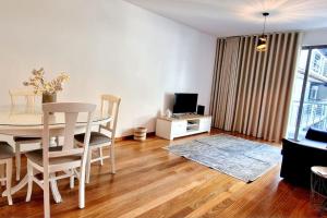 sala de estar con mesa, sillas y TV en Ocean Pearl Apartment W, en Funchal