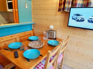 einem Holztisch mit blauen Platten darüber in der Unterkunft Studio Valfréjus, 1 pièce, 4 personnes - FR-1-468-95 in Valfréjus