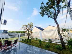 Hàm Tân的住宿－Sunrise House，白色的围栏,有椅子和树