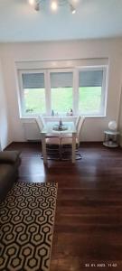 a living room with a table and two windows at Apartman Zelengaj in Zagreb