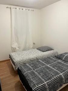 um quarto com duas camas e uma cortina em Appartement type T3 vaulx la soie em Vaulx-en-Velin