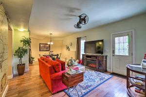 Una sala de estar con un sofá rojo y un televisor. en Fayetteville Apartment about 14 Mi to Atlanta Airport!, en Fayetteville