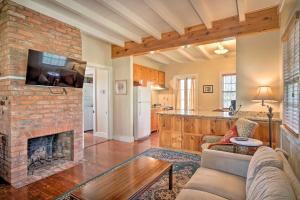 a living room with a brick fireplace and a kitchen at Idyllic Houma Vacation Rental on Shared Pond! in Houma