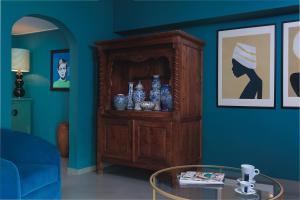 a living room with a wooden cabinet with vases on it at Kura Botanica Hotel in Willemstad