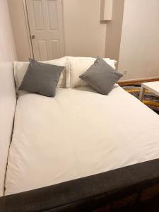 a white bed with two pillows on top of it at Imperial museum apartment in London