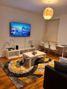 a living room with a table and a tv on the wall at Imperial museum apartment in London