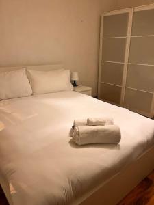 a white bed with two towels on top of it at Imperial museum apartment in London